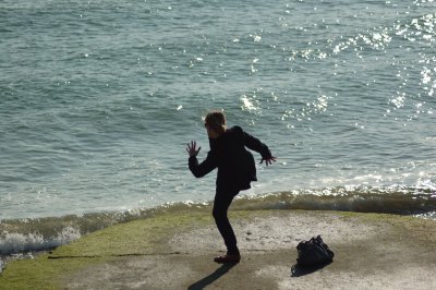 A person practising martial arts by the sea