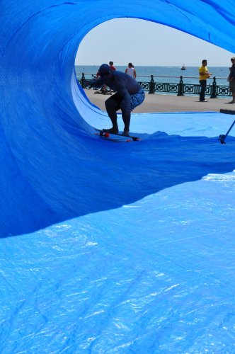 Person on skateboard going through a tarpaulin wave