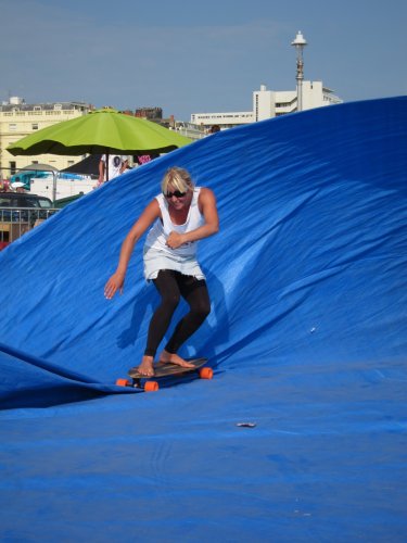 Surfer on a long board riding a blue tarpaulin